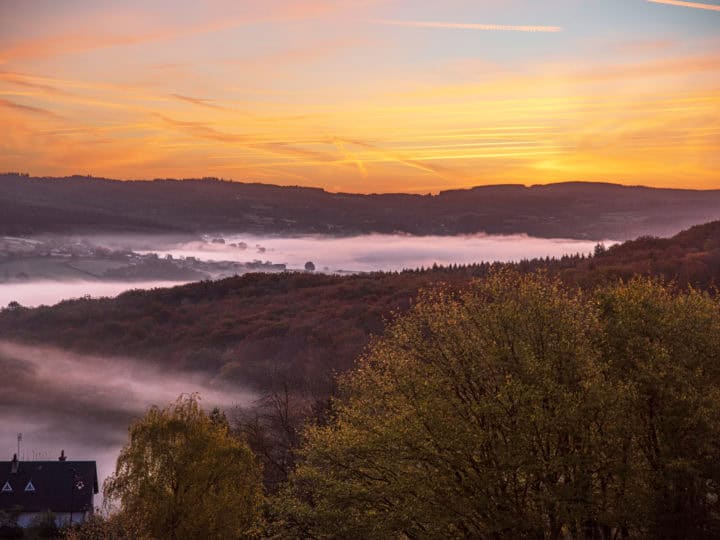 Autumn landscape in Burgundy at Château-Chinon in France, with forests, hills, and houses at sunrise