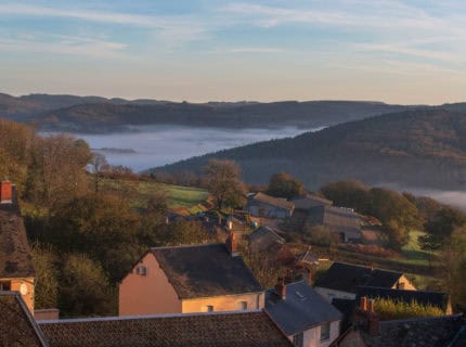 Autumn landscape in Burgundy at Château-Chinon in France, with forests, hills, and houses at sunrise